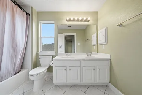 a bathroom with a double vanity sink mirror and toilet