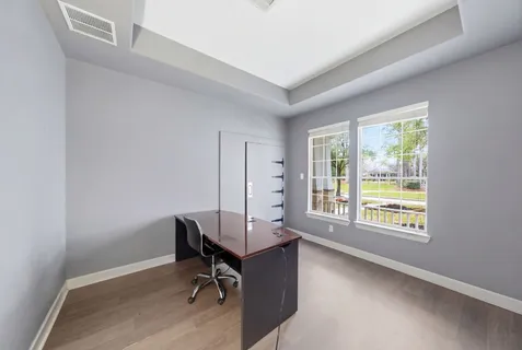 a view of a workspace with furniture and a window