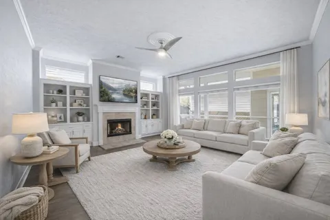 a living room with furniture a fireplace and a large window