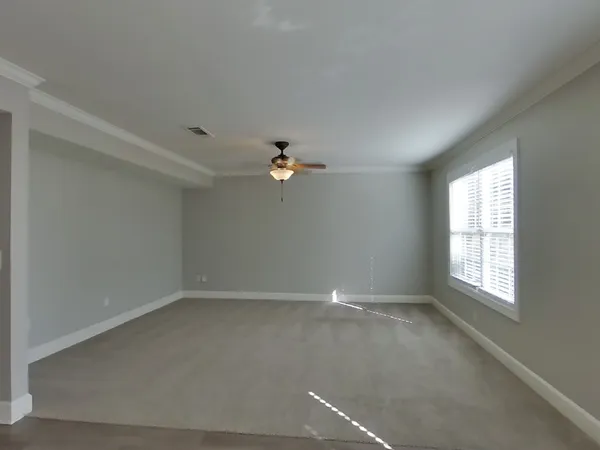 a view of a livingroom with a ceiling fan and window