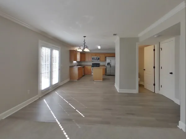 a view of a kitchen with a sink and dishwasher a refrigerator with wooden floor