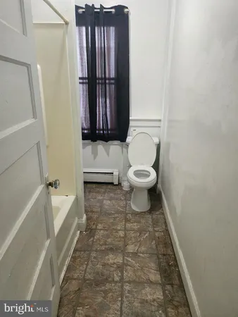 a bathroom with a toilet and a tub