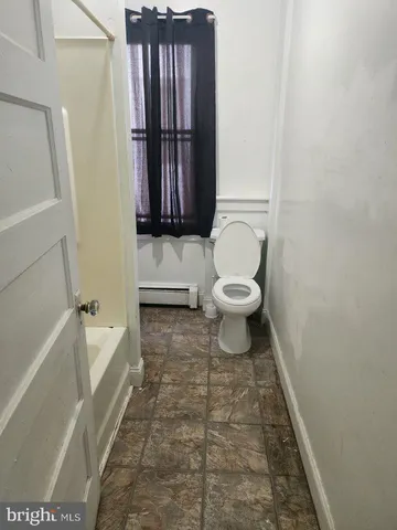a bathroom with a toilet and a tub