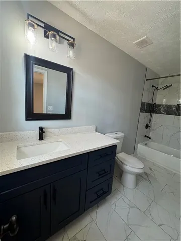 a bathroom with a toilet sink double vanity and mirror