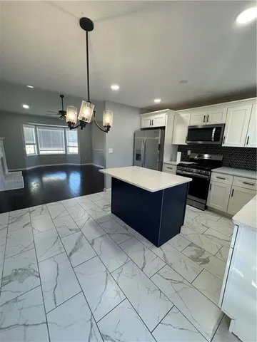 a large kitchen with kitchen island a counter a sink a counter space and cabinets