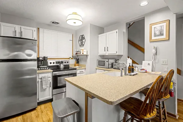 a kitchen with a stove a refrigerator and a dining table