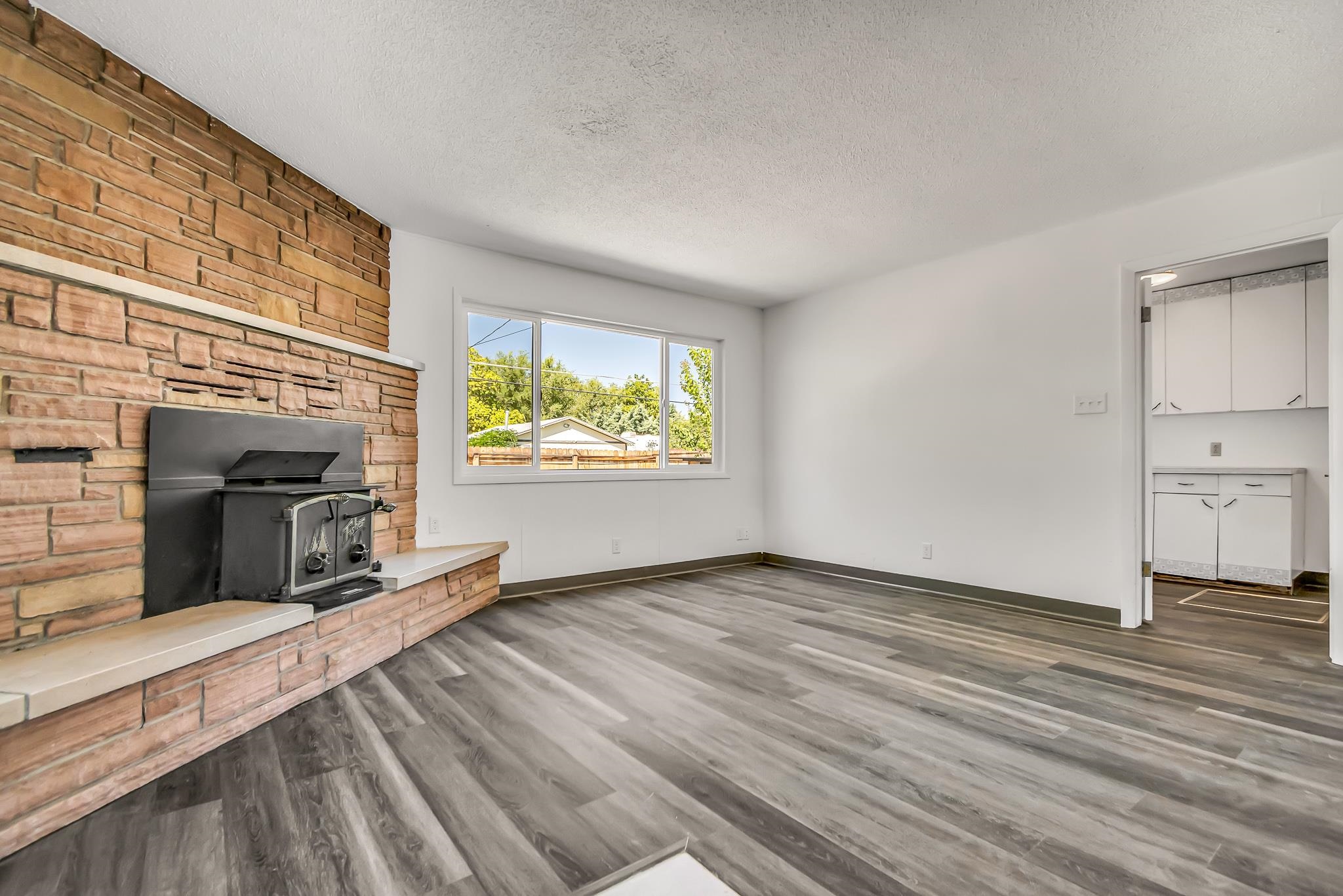 253 Nancy Street Grand Junction, CO 81503 - Photo 10 of 26 an empty room with wooden floor fireplace and windows