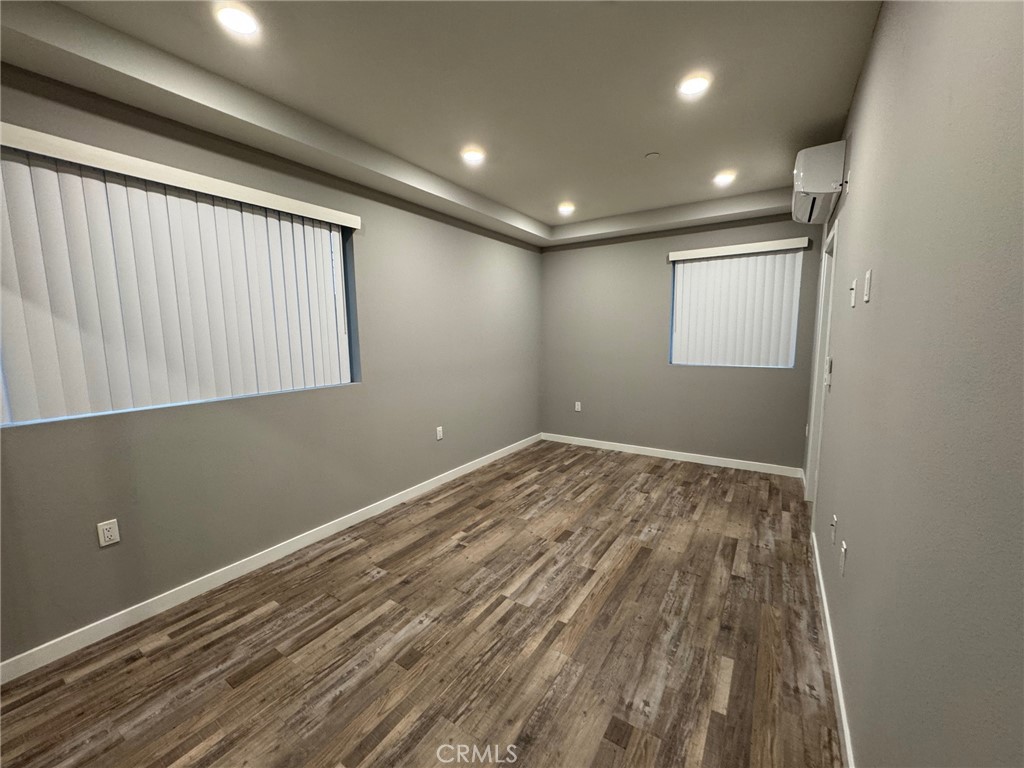 623 Normandie Avenue Los Angeles, CA 90004 - Photo 15 of 23 an empty room with wooden floor and windows
