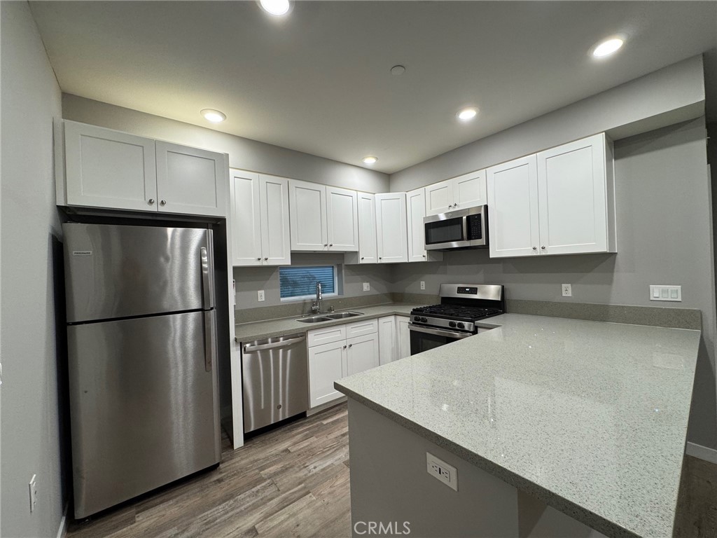 623 Normandie Avenue Los Angeles, CA 90004 - Photo 8 of 23 a kitchen with a refrigerator a microwave and cabinets