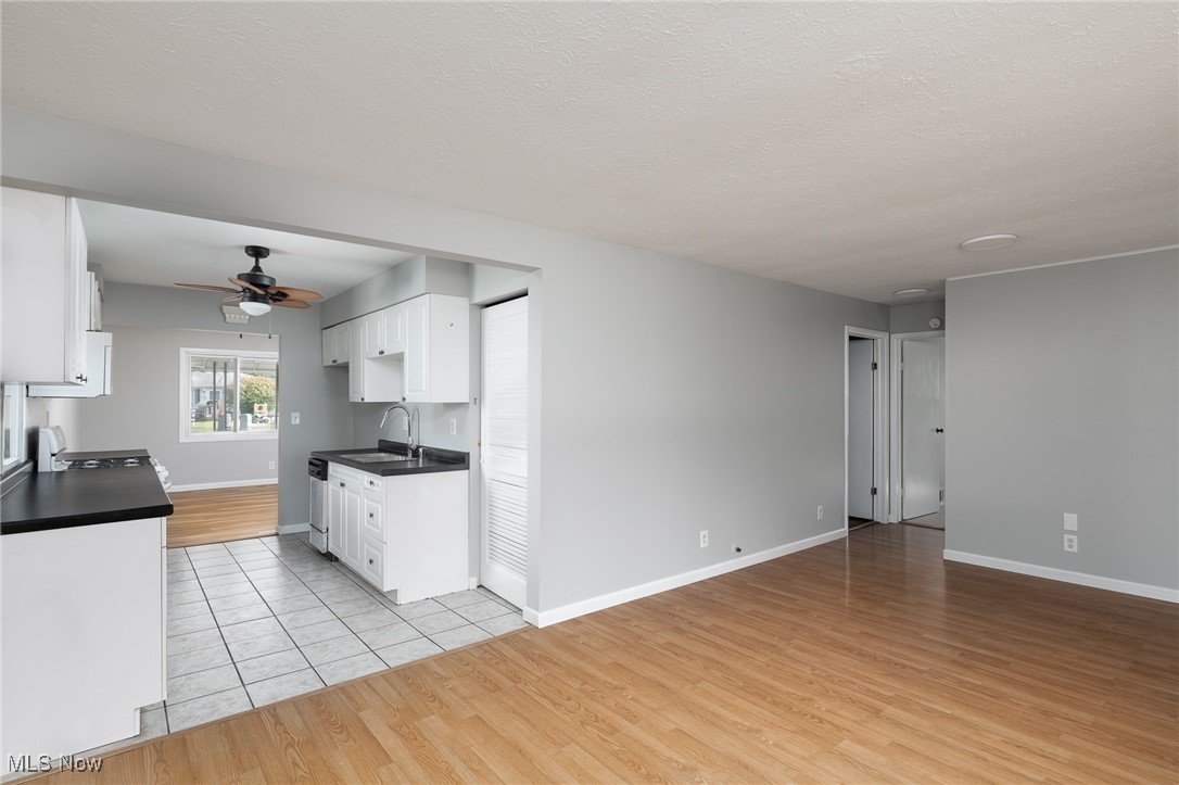 4782 Belle Meadow Road Mentor, OH 44060 - Photo 12 of 22 Kitchen with white cabinetry, dishwasher, a textured ceiling, ceiling fan, and light hardwood / wood-style flooring