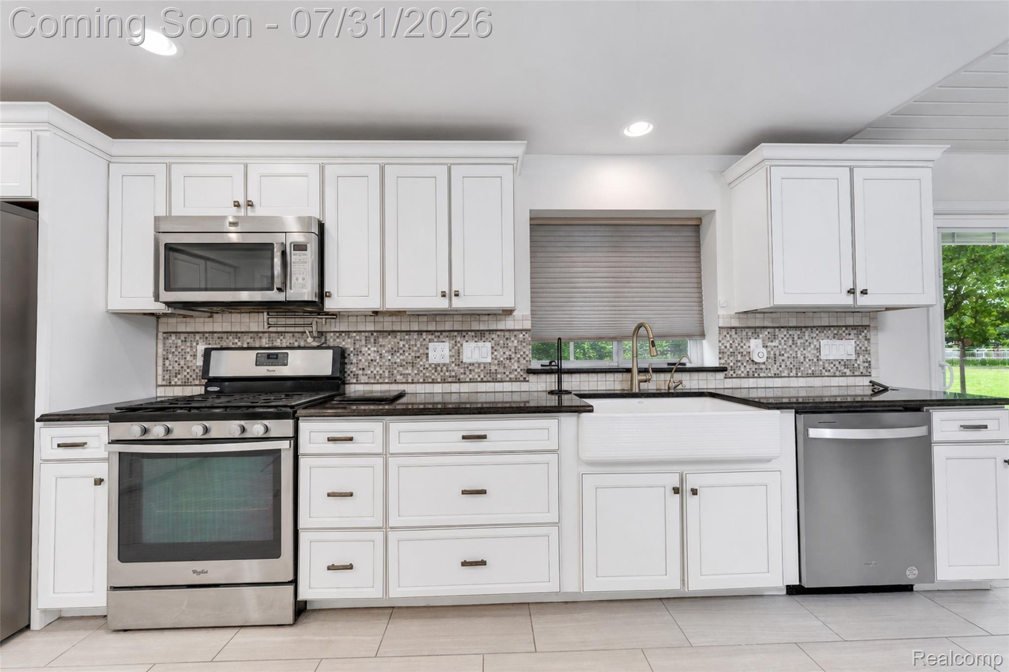 5269 Reno Road Manchester, MI 48158 - Photo 40 of 64 Kitchen featuring white shaker cabinetry, dark countertops, a farmhouse sink, stainless steel appliances, and a mosaic tile backsplash