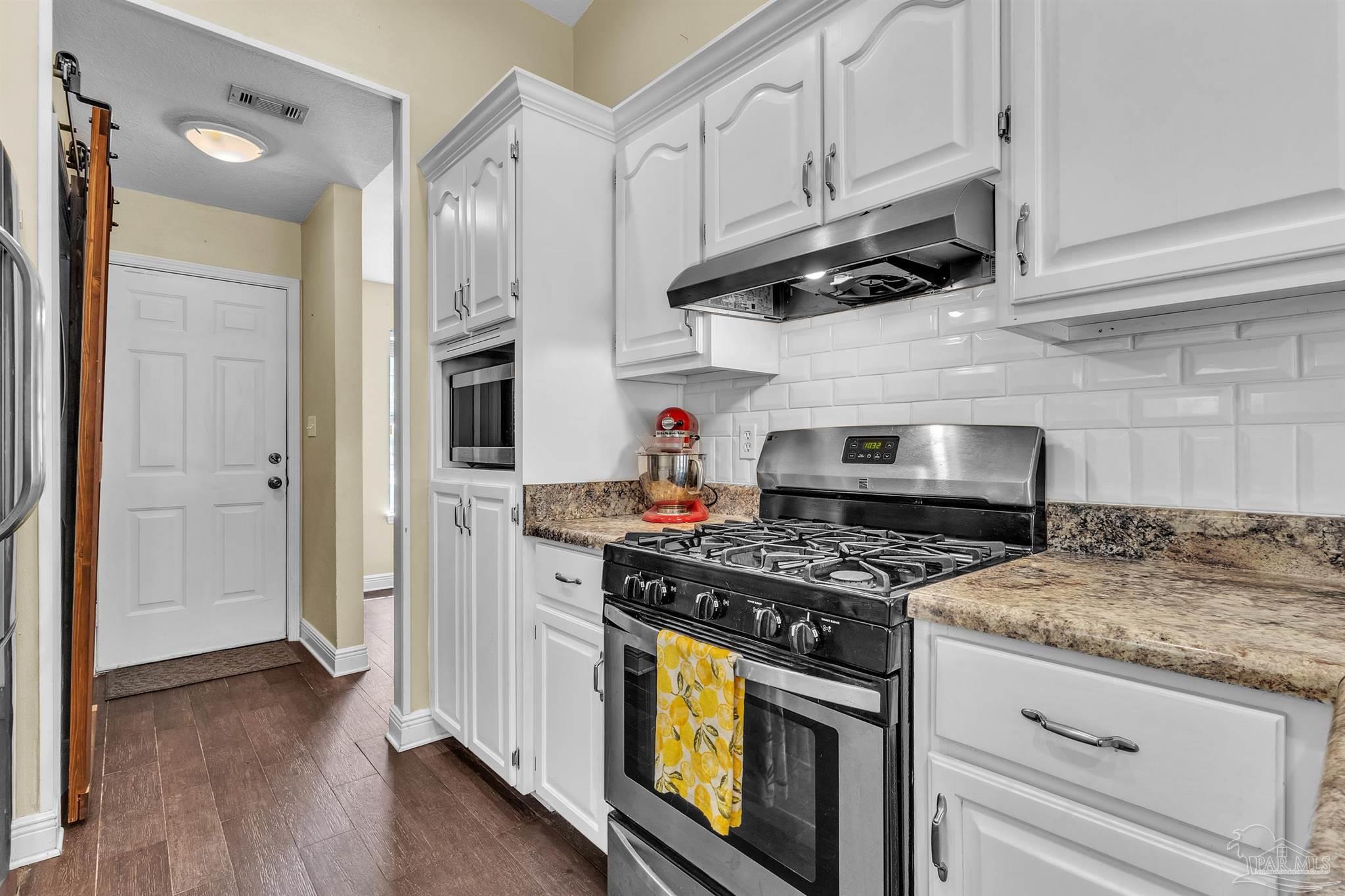 4321 Ridgeland Drive Pace, FL 32571 - Photo 11 of 36 a kitchen with stainless steel appliances granite countertop a stove and a refrigerator