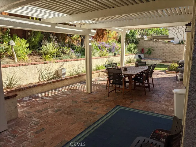 a view of a chair and table in backyard of the house