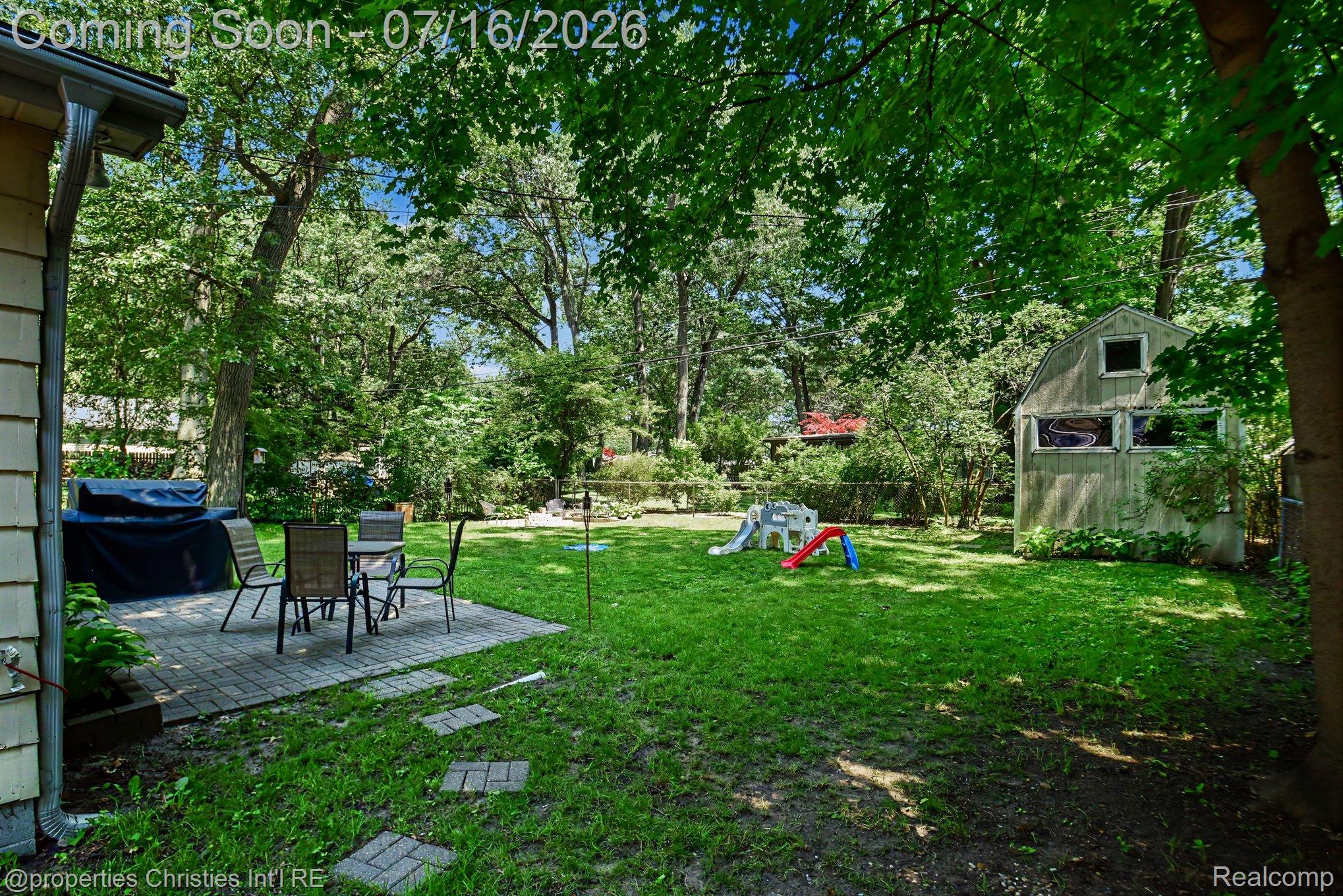 3304 Riverside Drive Port Huron, MI 48060 - Photo 26 of 26 Spacious backyard with mature trees, a paver patio, stepping stone pathway, and a detached storage shed