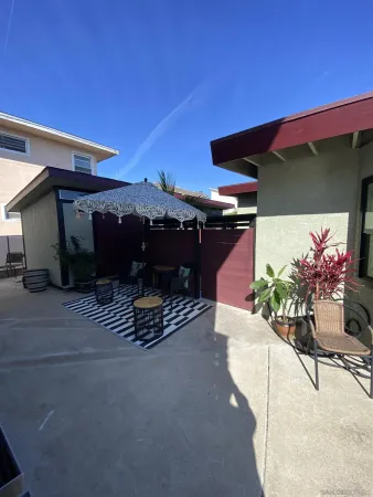 a roof deck with table and chairs and potted plants