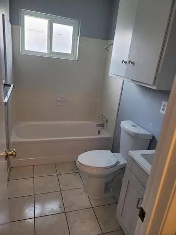 a view of an empty room with wooden floor and closet