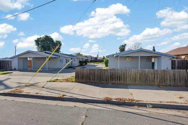 a view of a house with a small yard and wooden fence