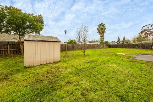 a view of a backyard with wooden fence
