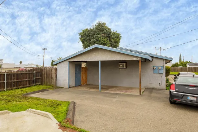 a front view of a house with a garden and parking