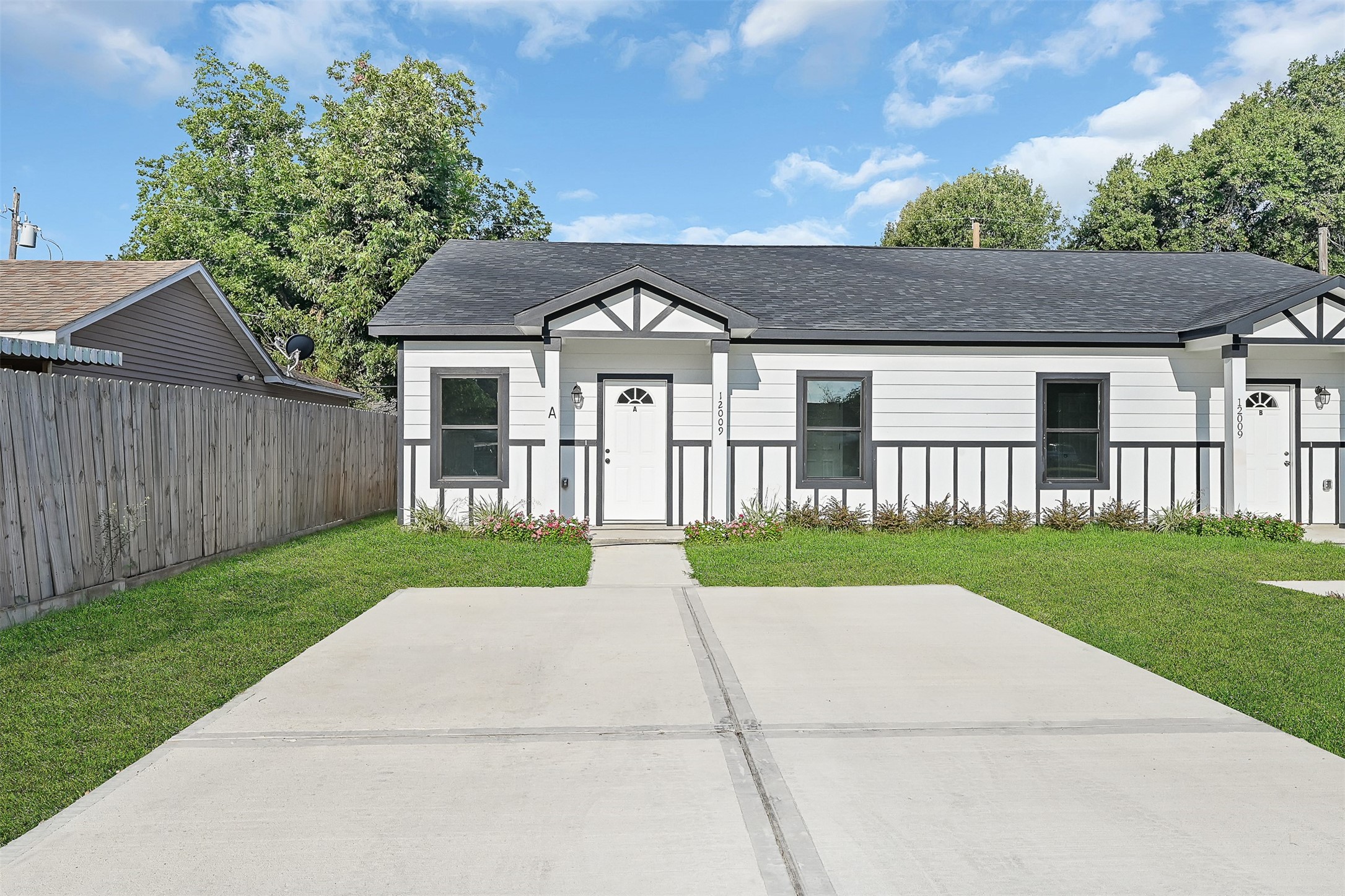 12009 Meadowgreen Street, Unit A Houston, TX 77076 - Photo 3 of 20 a front view of a house with a yard and garage