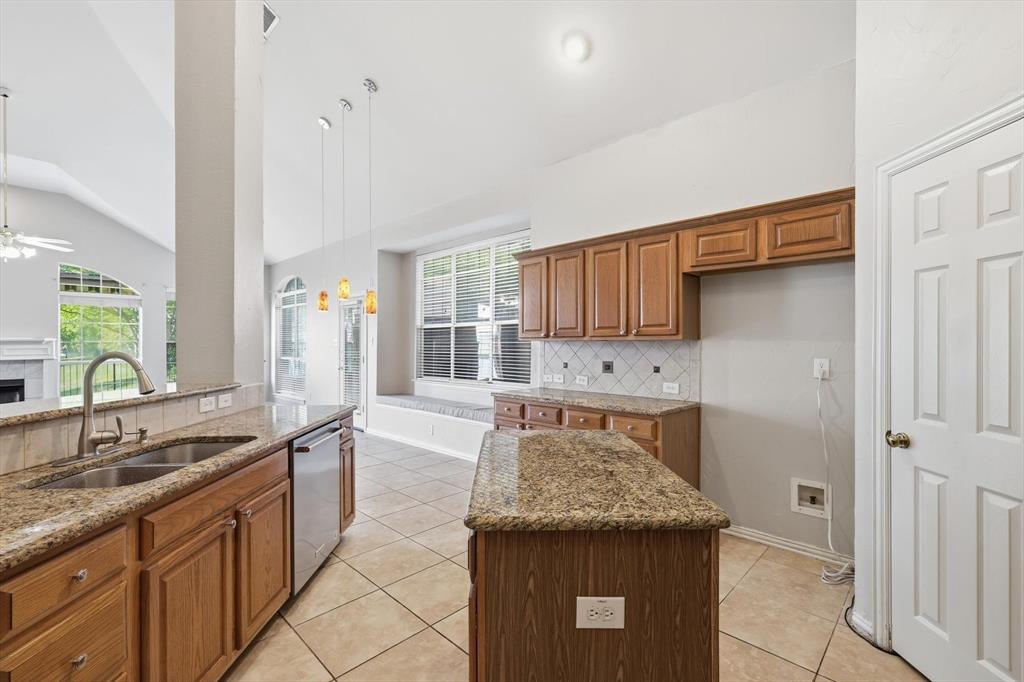 103 Ranch Trail Irving, TX 75063 - Photo 12 of 39 Kitchen has an open plan and has island, granite, large serving bar, stl. steel appl. & a gas cooktop & oven.