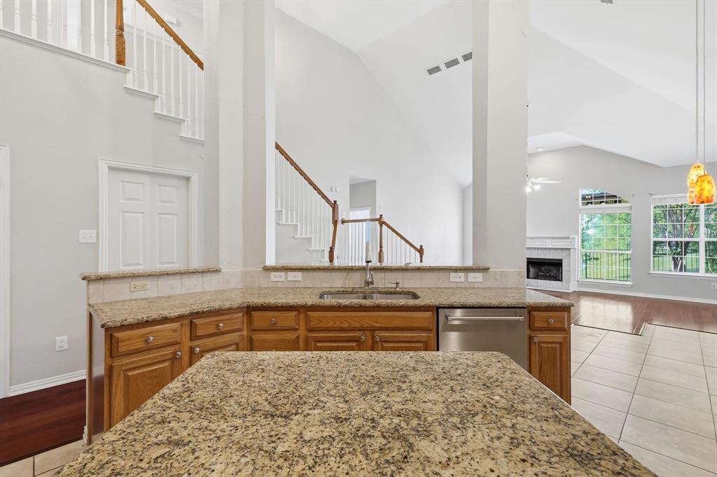 103 Ranch Trail Irving, TX 75063 - Photo 13 of 39 Kitchen has an open plan and has island, granite, large serving bar, stl. steel appl. & a gas cooktop & oven.