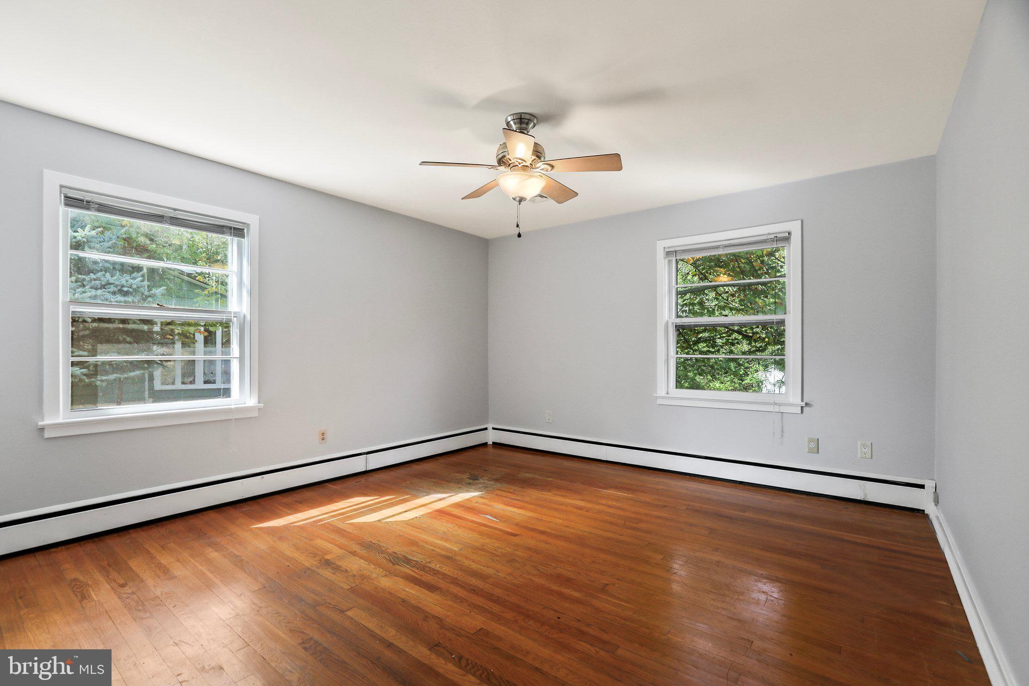 120 West Upper Ferry Road Ewing, NJ 08628 - Photo 14 of 27 an empty room with wooden floor chandelier fan and windows