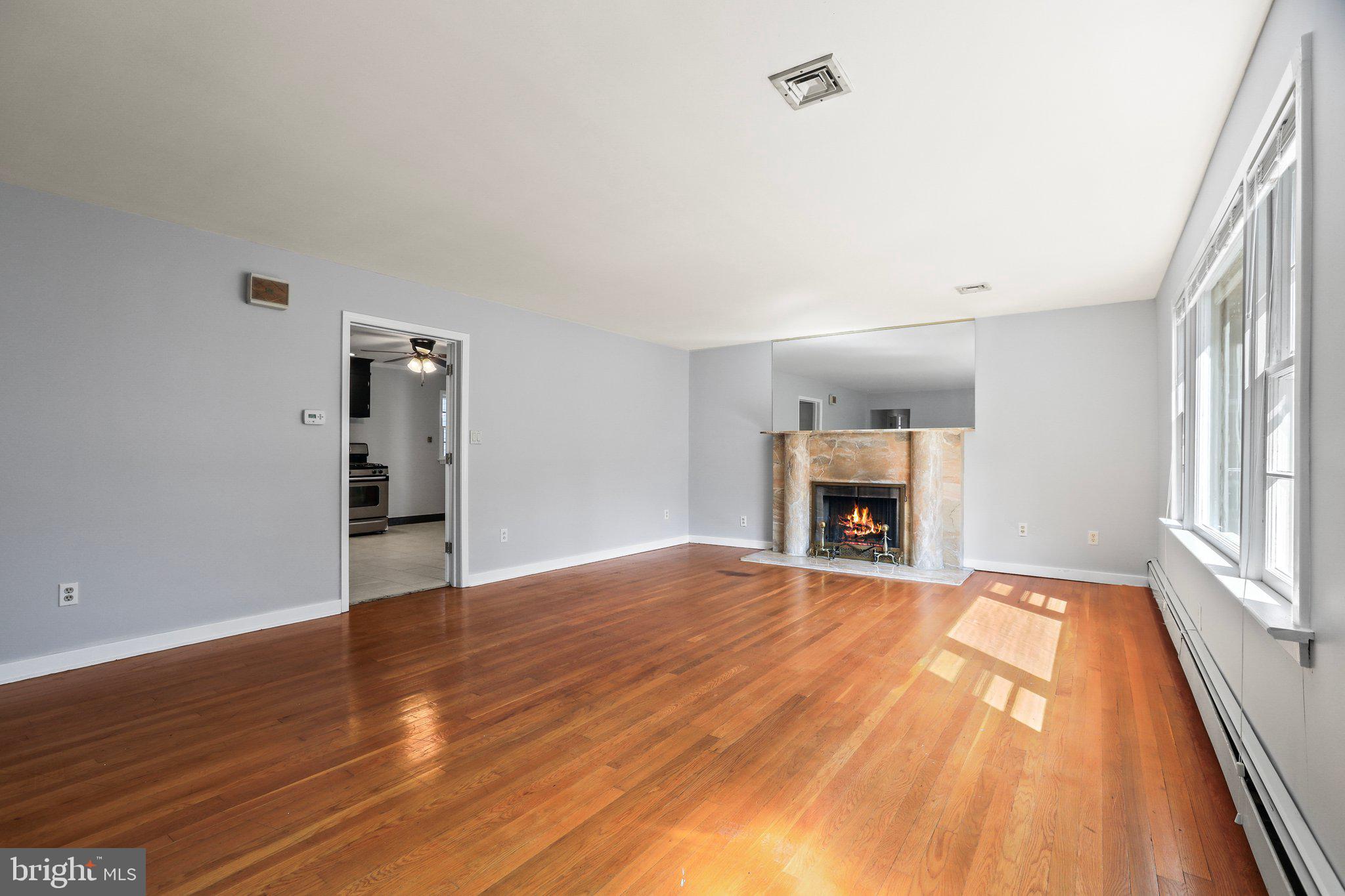 120 West Upper Ferry Road Ewing, NJ 08628 - Photo 6 of 27 a view of an empty room with wooden floor fireplace and a window