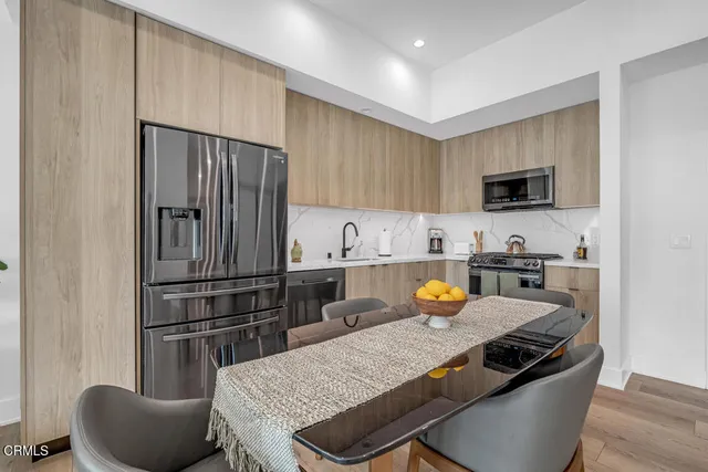 a kitchen with a refrigerator and a stove top oven
