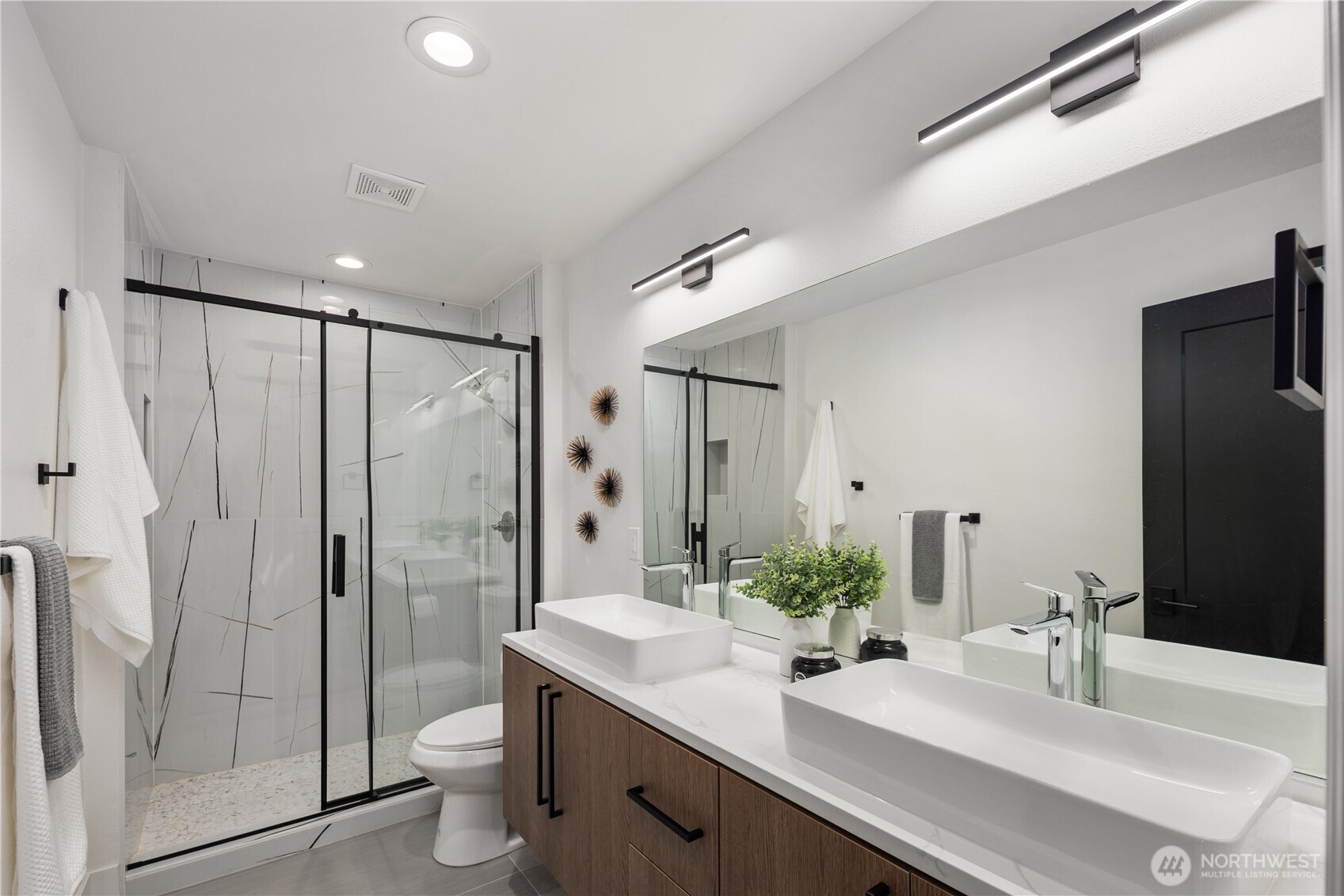 11127 Northeast 162nd Street Bothell, WA 98011 - Photo 19 of 40 a bathroom with a double vanity sink toilet and shower