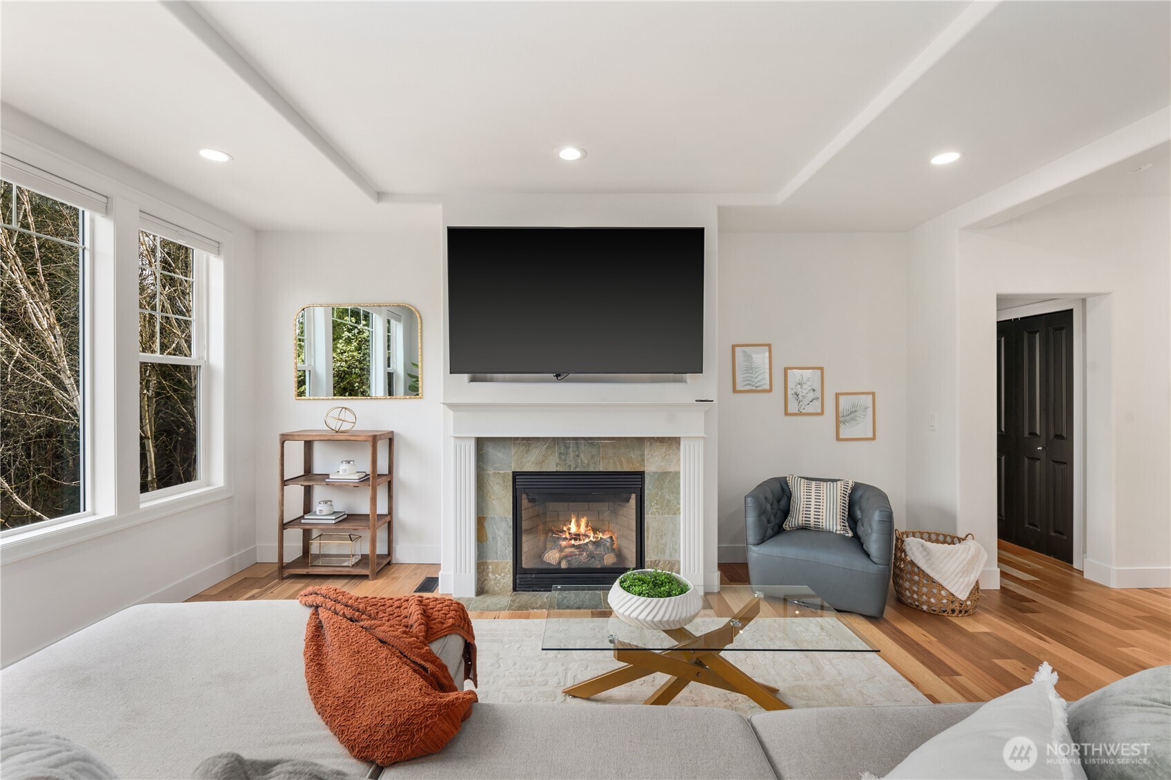 11127 Northeast 162nd Street Bothell, WA 98011 - Photo 10 of 40 a living room with furniture a flat screen tv and a fireplace