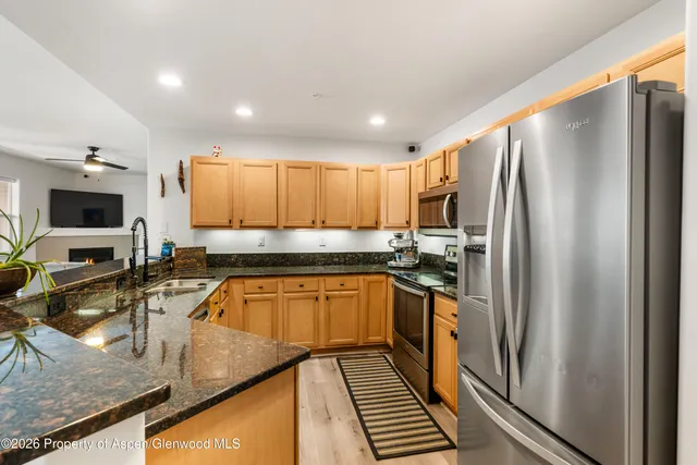 a kitchen with stainless steel appliances granite countertop a refrigerator and a stove top oven