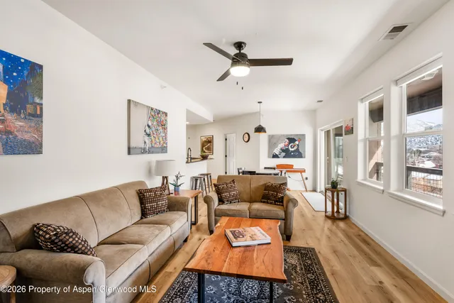 a living room with furniture and a wooden floor