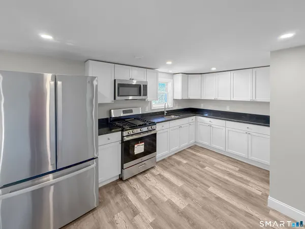 a kitchen with cabinets stainless steel appliances and a window