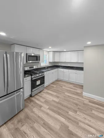 a kitchen with stainless steel appliances granite countertop a refrigerator and a stove top oven