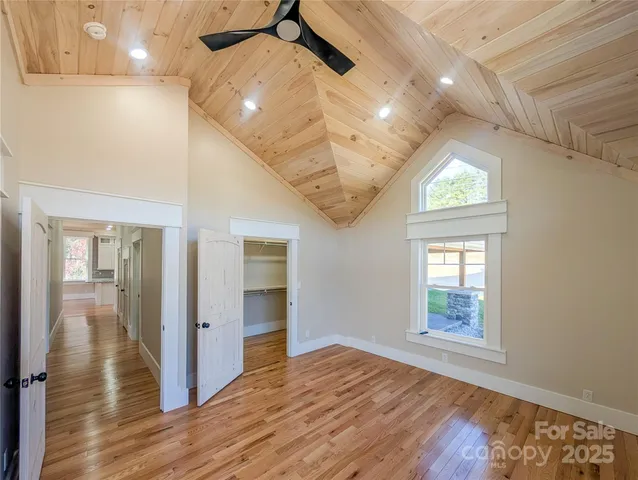 en empty room with wooden floor and hallway