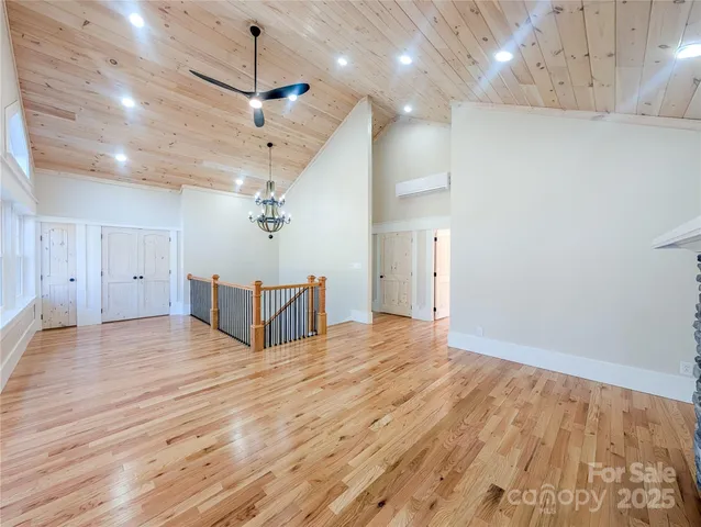 a view of a livingroom with a ceiling fan wooden floor and chandelier
