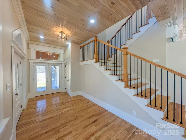 a view of a hallway with wooden floor and entryway