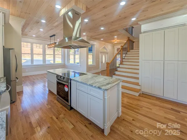 a kitchen with stainless steel appliances granite countertop a stove and a wooden floors