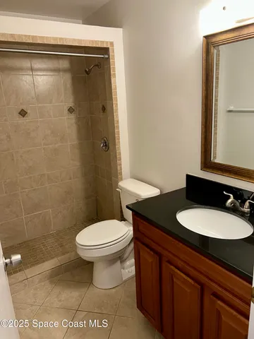 a bathroom with a granite countertop sink toilet and a mirror