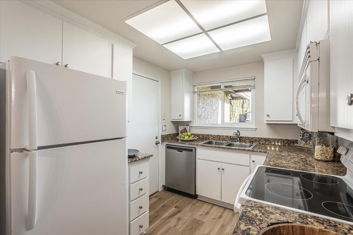 1726 Merrill Loop San Jose, CA 95124 - Photo 13 of 41 a kitchen with granite countertop a refrigerator sink stove and white cabinets