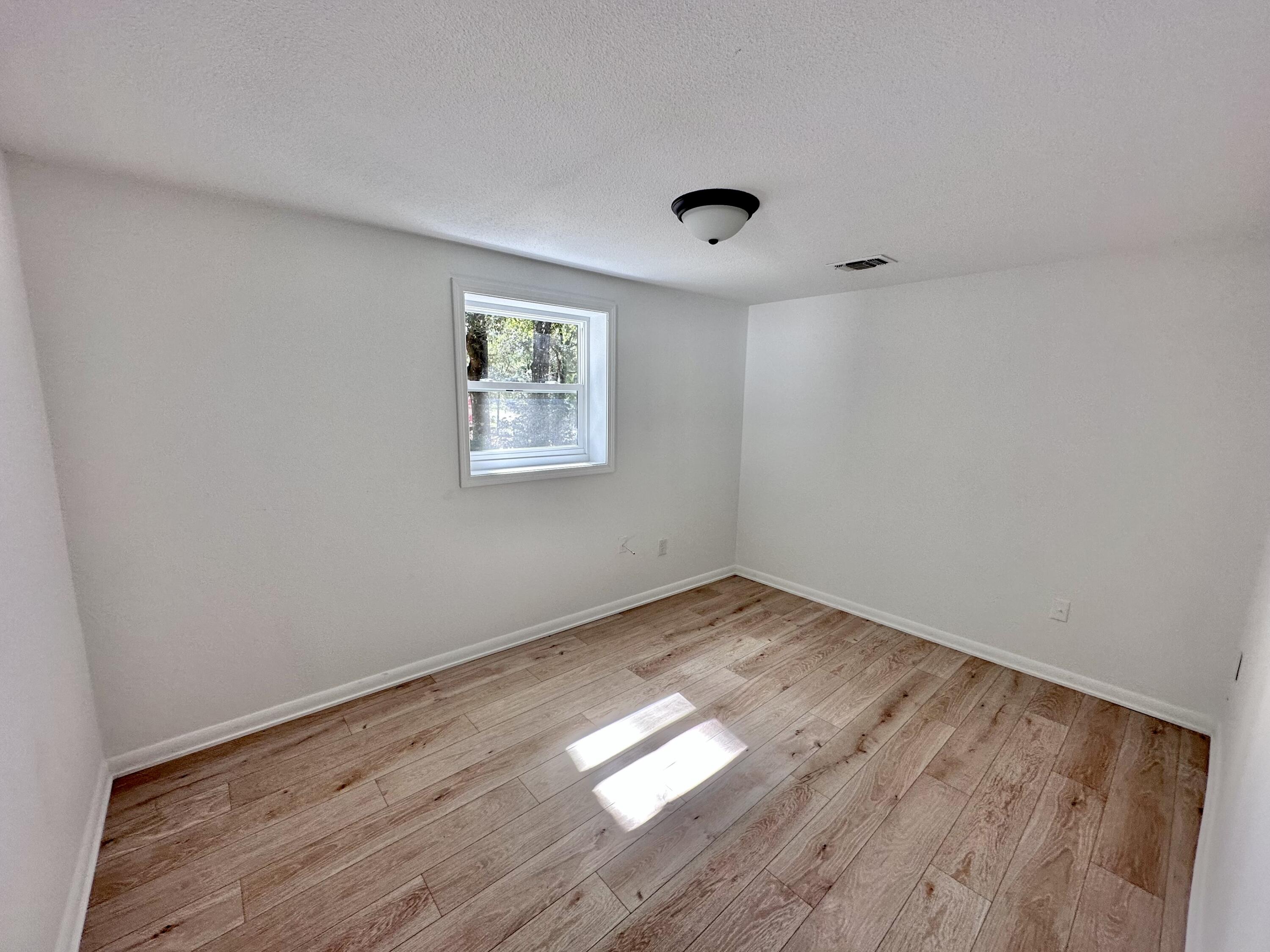 159 Smith Street Crestview, FL 32539 - Photo 15 of 29 an empty room with wooden floor and windows