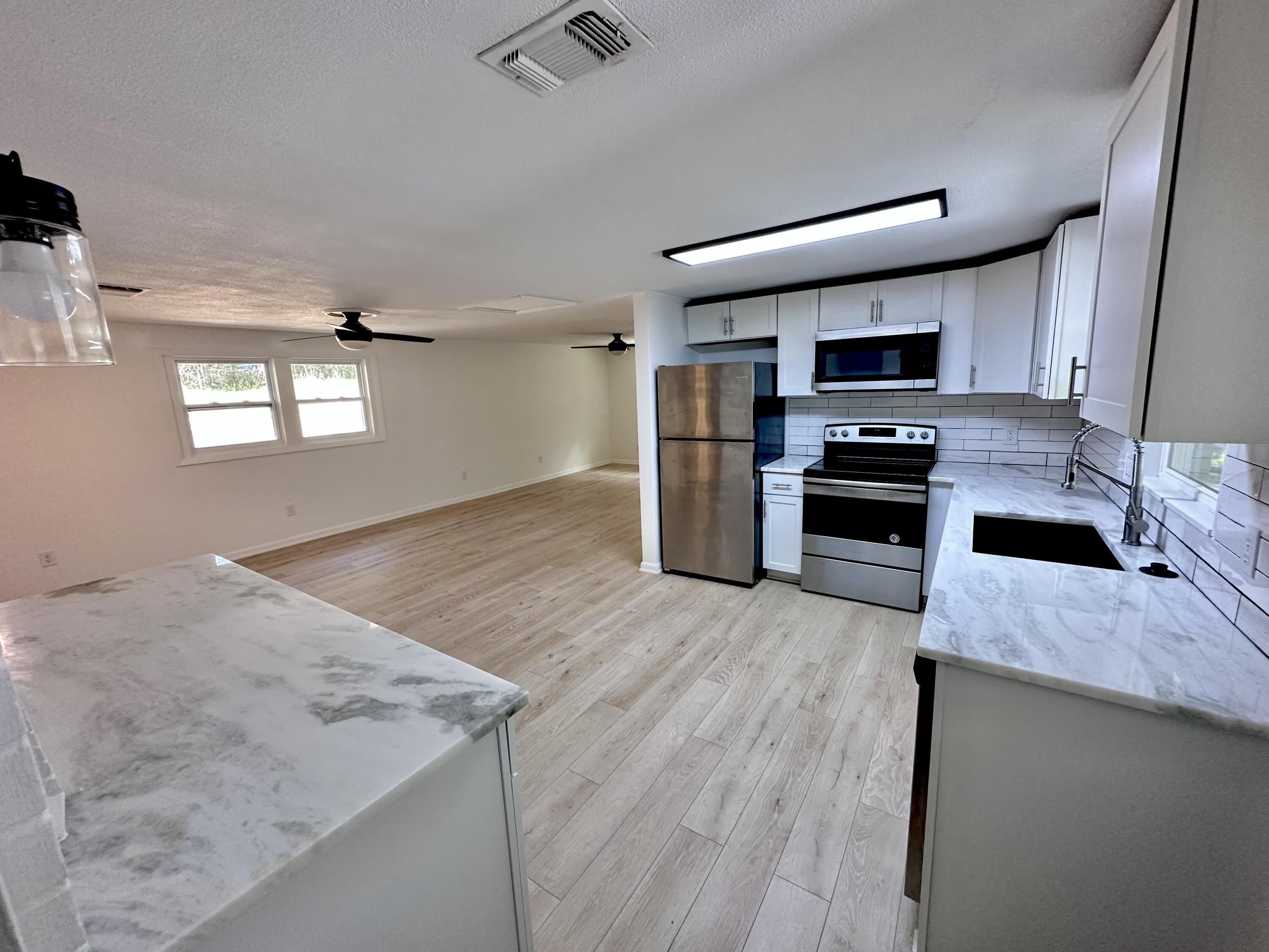 159 Smith Street Crestview, FL 32539 - Photo 6 of 29 a kitchen with stainless steel appliances granite countertop a sink stove and refrigerator