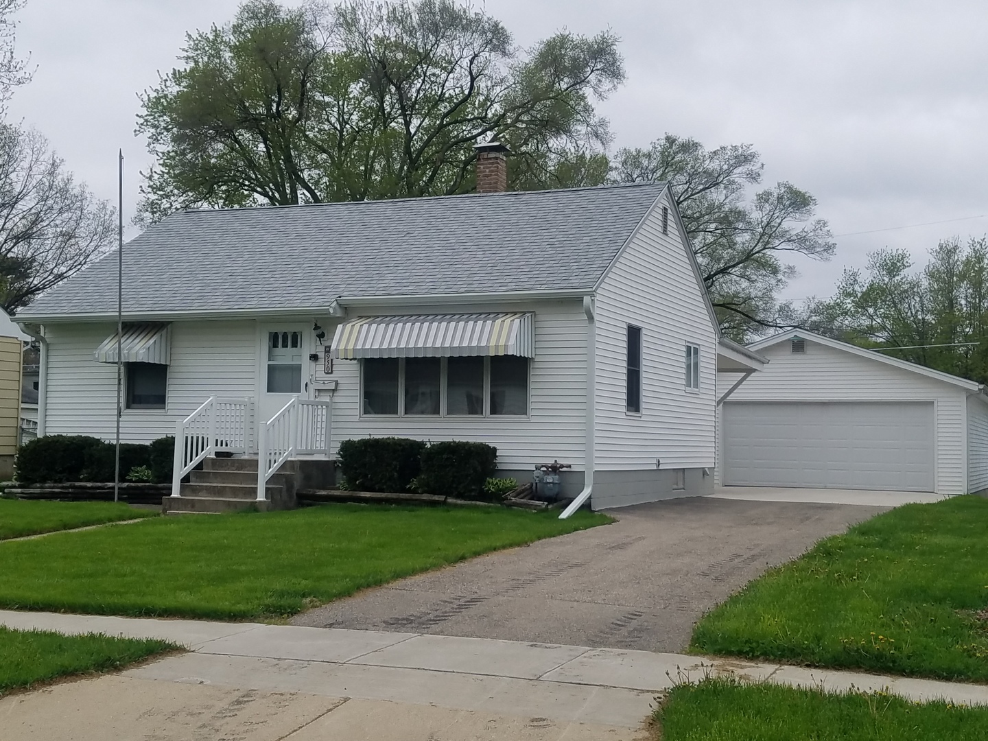 a front view of a house with a yard and trees