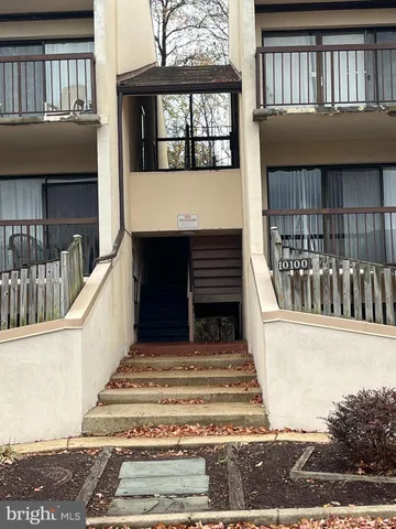 a view of a brick house with large windows and a flower plants