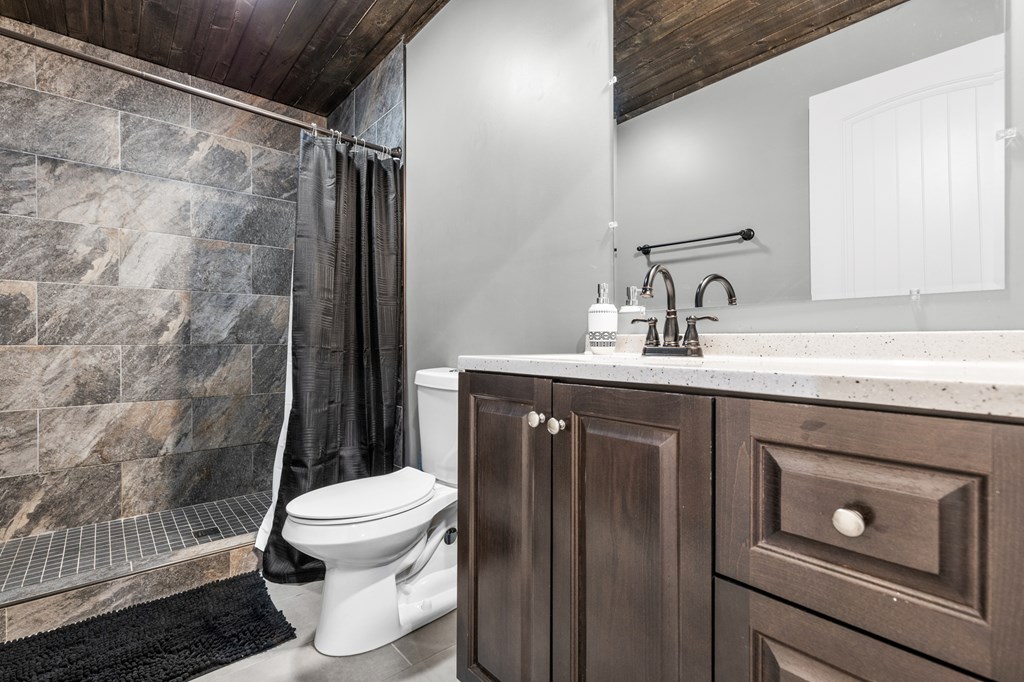 41 Brumby Trail Ellijay, GA 30536 - Photo 34 of 39 a bathroom with a granite countertop sink toilet and shower