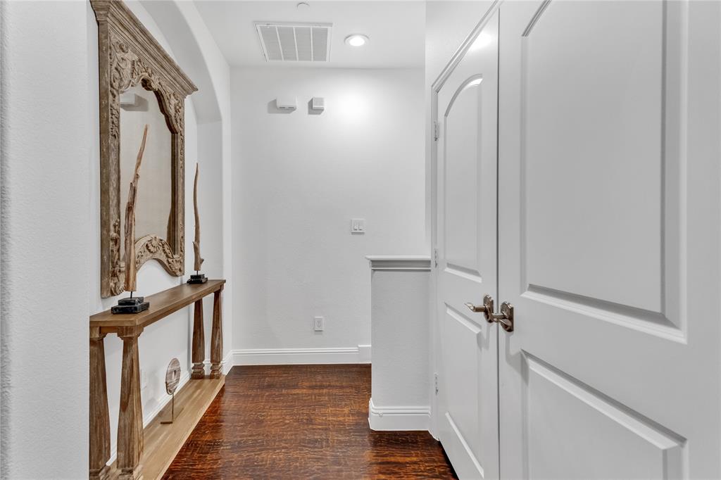 5744 Robbie Road Plano, TX 75024 - Photo 22 of 32 Hallway with wood-finish flooring, white paneled doors, and arched architectural detailing