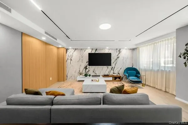 a living room with furniture a flat screen tv and a window
