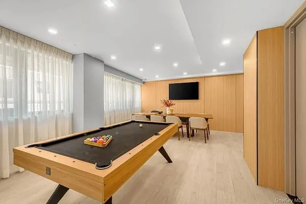 a living room with pool table and a flat screen tv
