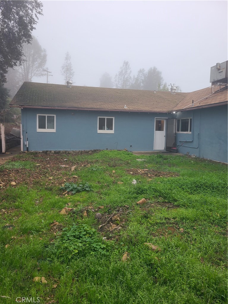 141 Rutherford Lane Oroville, CA 95966 - Photo 2 of 9 a house that is sitting in the grass with large trees